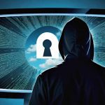 A person wearing a hooded jacket is silhouetted against a large computer screen. The screen displays a keyhole symbol in the center with a cloudy sky visible through it. Surrounding the keyhole are lines of code and digital data radiating outward. The scene is illuminated with a blue glow, emphasizing the technological and cyber-centric theme.