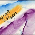 Screenshot of a digital painting application showing a canvas with a watercolour-style painting. The artwork features broad strokes of blue, purple, and orange, with the words "Pigment + Paper" handwritten in black over the orange section. The interface includes various brush tools on the left, colour palettes and layers panel on the right, and brush customization options in the center-left. The canvas has a textured, paper-like appearance.