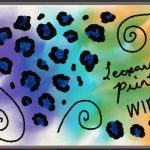 The image shows a digital art interface displaying a colorful background with a leopard print pattern in progress. The background features a gradient blend of colors including blue, green, orange, and purple. Over this background, there are black leopard spots with blue centers scattered throughout the canvas. Three large spiral shapes are drawn in black, and handwritten text in black ink reads “Leopard print WIP” (Work In Progress). The software interface includes various drawing tools, brushes, color palettes, and layer controls.