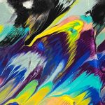 Abstract painting with vivid, fluid streaks of color blending across the paper. Prominent hues include bright yellow, turquoise, cobalt blue, peach, and purple, interspersed with black and white. The colors appear to be dragged or poured, creating feathered, wave-like textures. The upper corners feature heavier black and grey areas, adding contrast. In the bottom right corner, the artwork is signed “T Cowley” with the caption “Art & Design by Teresa Cowley.”